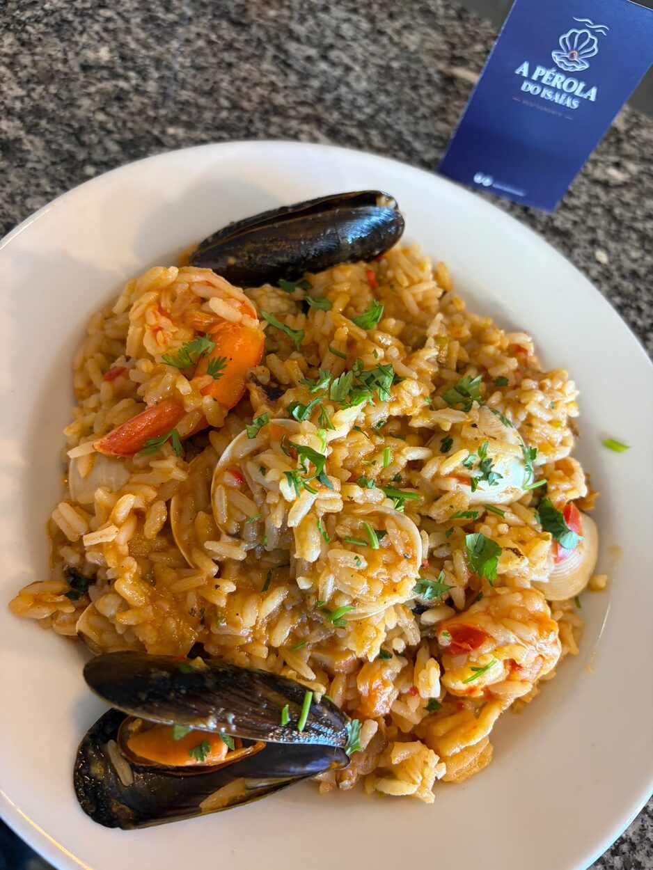 Arroz con mariscos peruano com camarão, mexilhão e amêijoas, numa mesa de A Pérola do Isaías