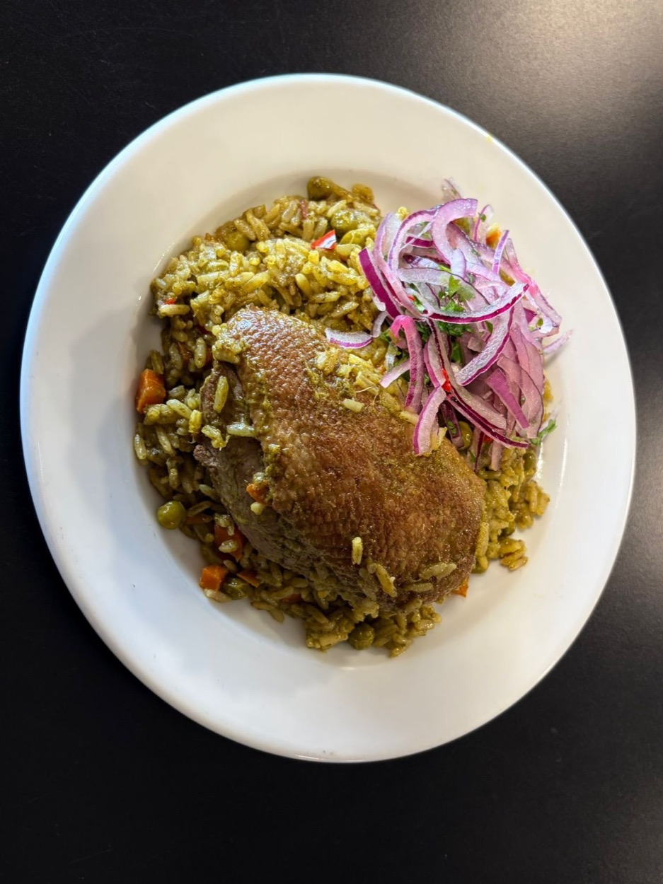 Arroz con pato, pato sobre arroz verde de coentros com cebola roxa