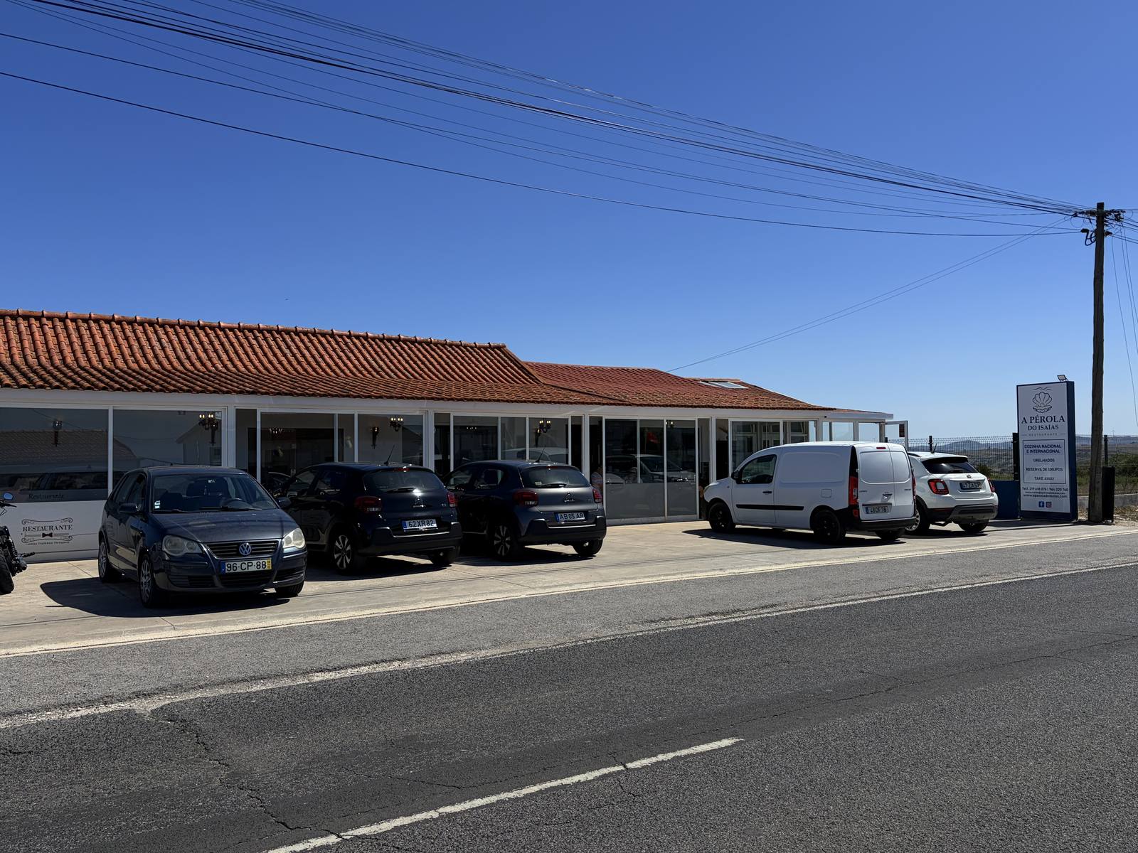 A Pérola do Isaías vista da EN247, com carros estacionados à porta