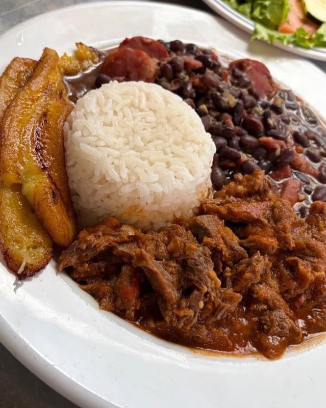 Pabellón criollo com carne desfiada, feijão preto, arroz e banana-da-terra frita