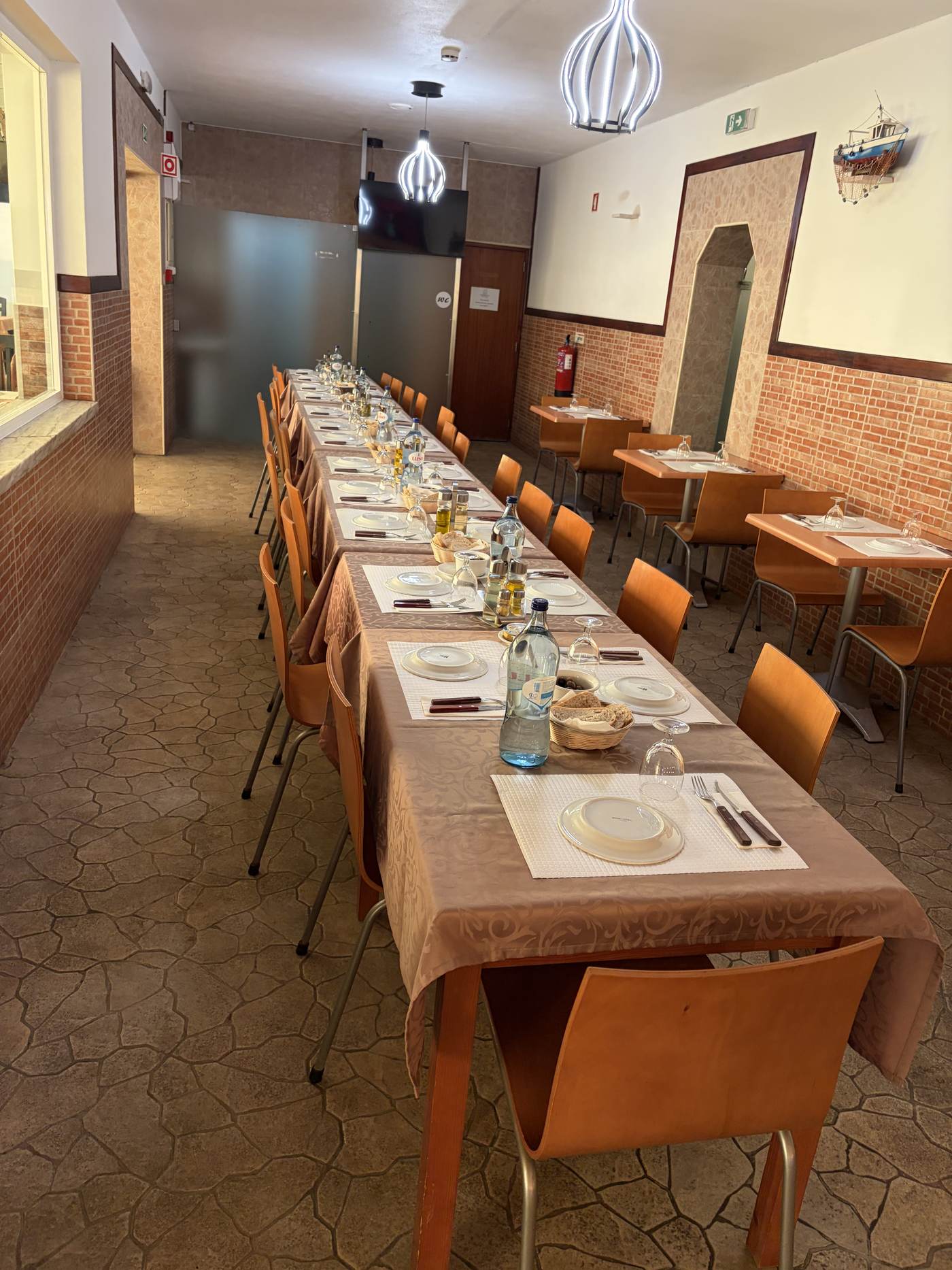 Sala interior com uma mesa comprida posta para um grupo